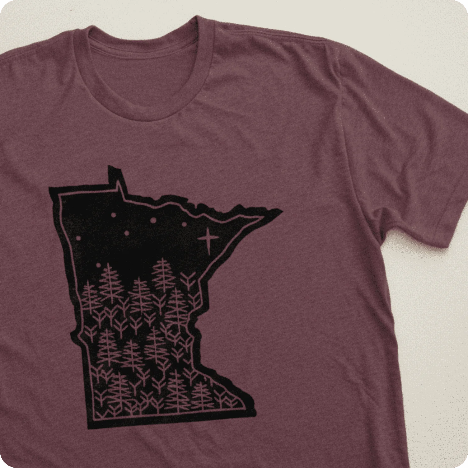 T-shirt featuring geographic silhouette design filled with minimalist forest illustration.