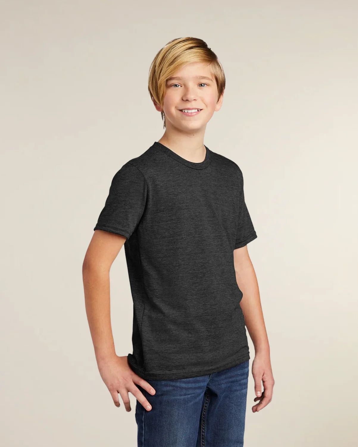 A youth model wearing a space black eco-friendly triblend t-shirt from Allmade.