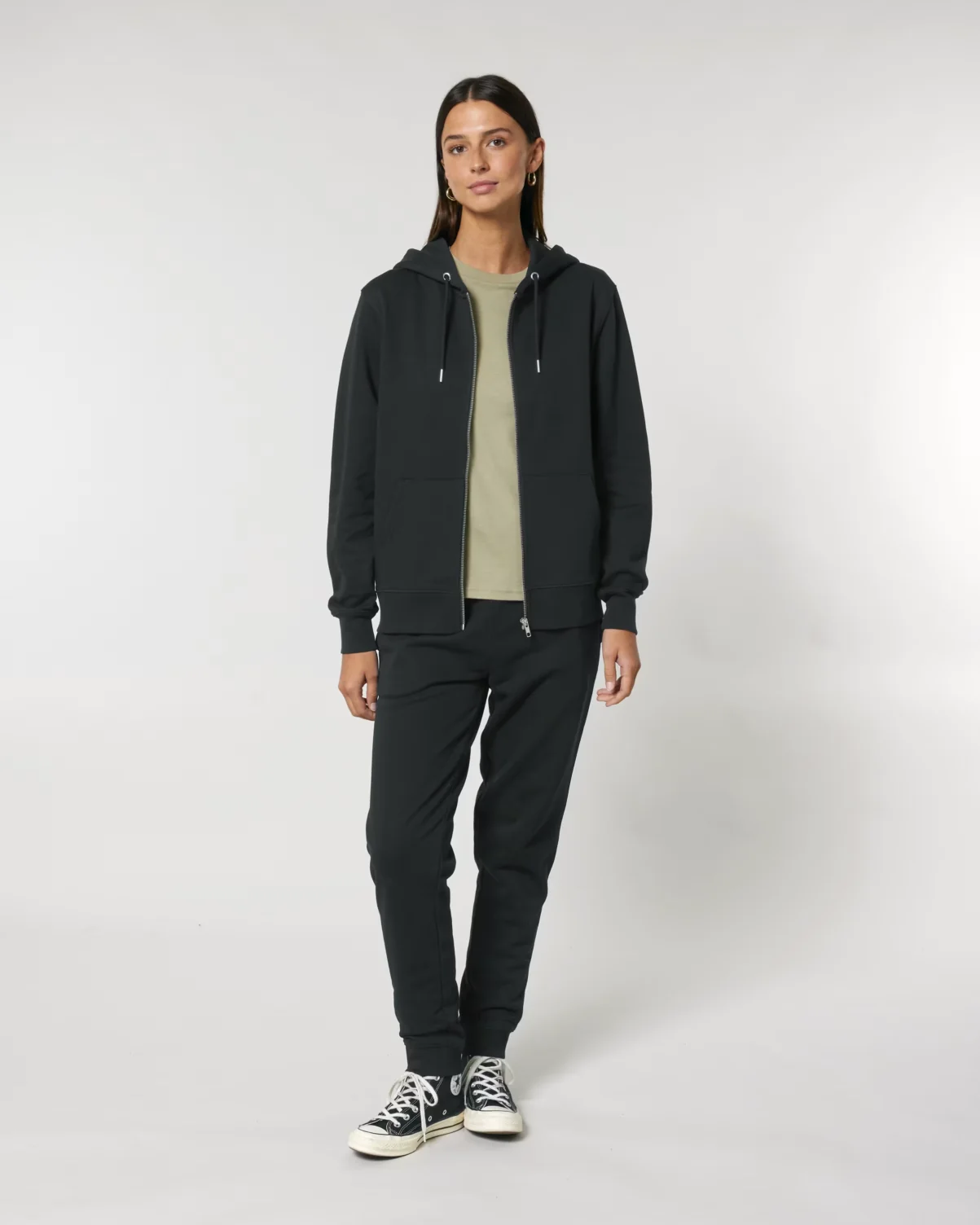 A female model wearing the eco-friendly Stanley/Stella Cultivator 2.0 Zip-Up Hoodie in black. It has a relaxed fit and clean, heavyweight look.